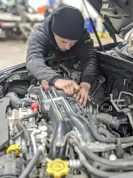 A Guaranty Auto technician working on an engine