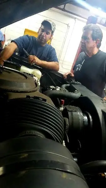 Two Guaranty Auto technicians working at an engine bay